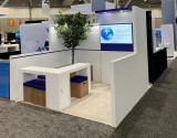 Recently Sold Used Booth! - Custom 10' x 10' White Trade Show Booth with White Corner Desk & 4 Padded Seats