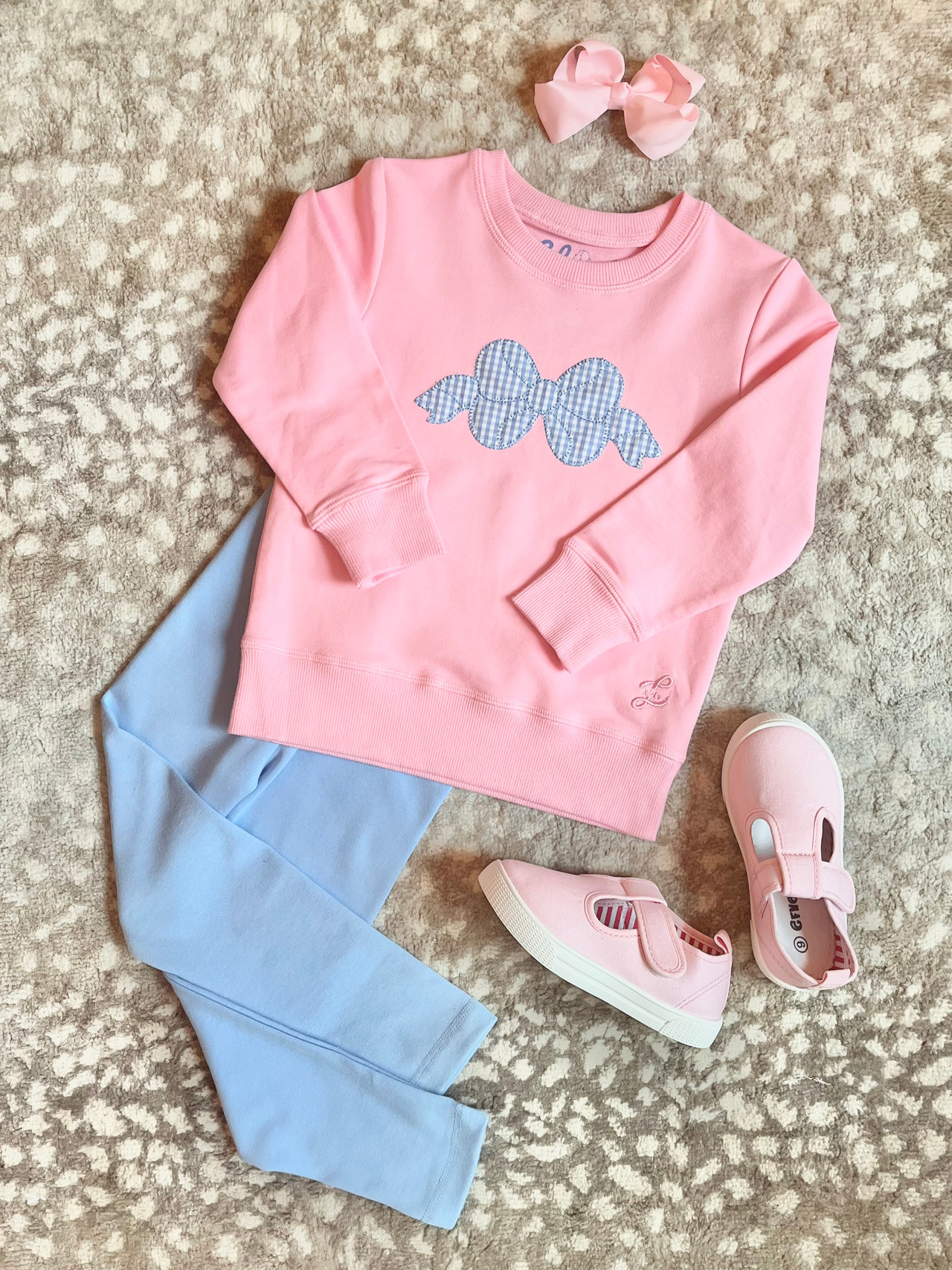 pink sweatshirt with blue gingham bow applique. shown with blue leggings and pink shoes for outfit inspiration.