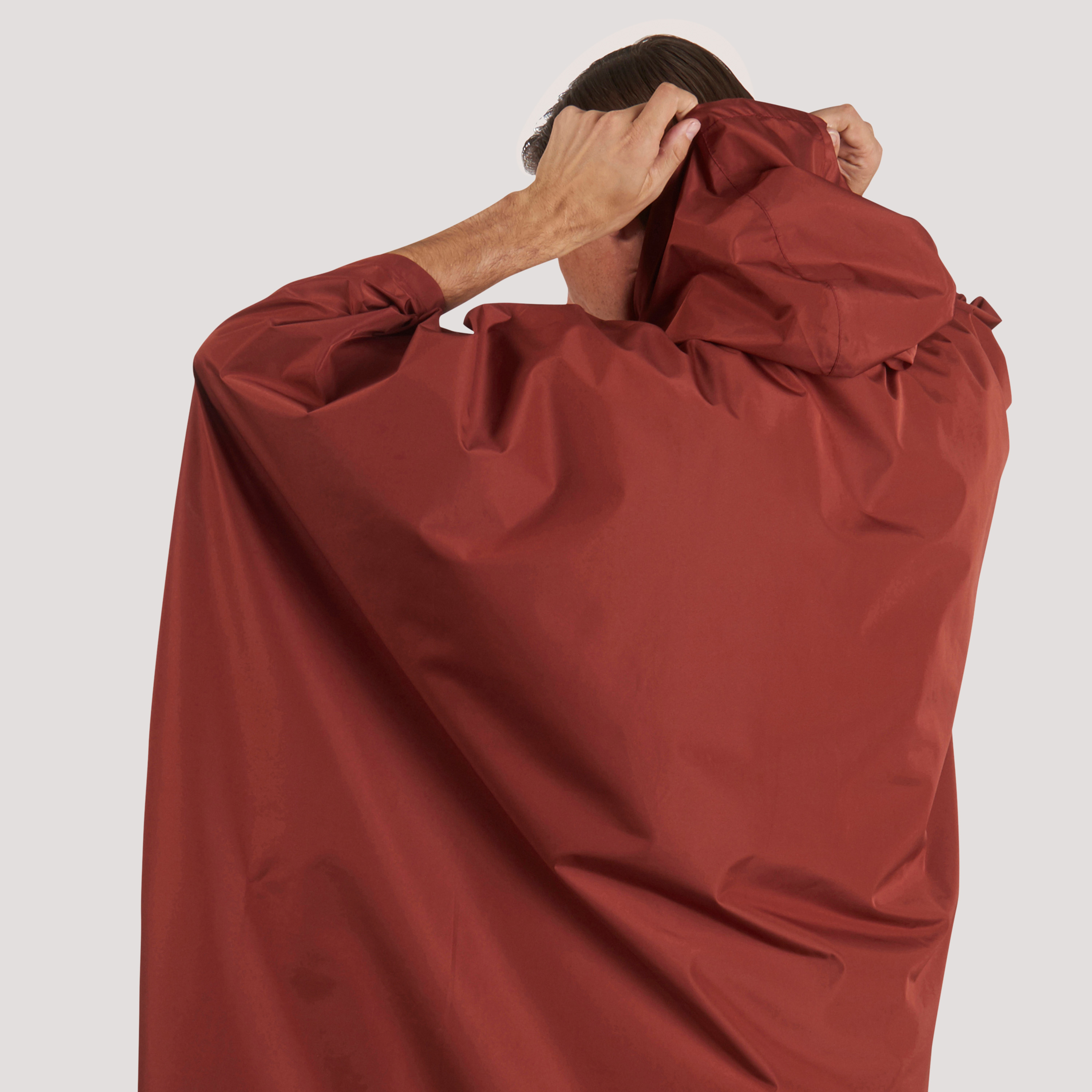 Man adjusting the hood of his Sierra Designs Adult Poncho