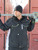 Black-Extreme Hooded Jacket man wearing extreme hooded jacket holding a large wrench outside in the snow