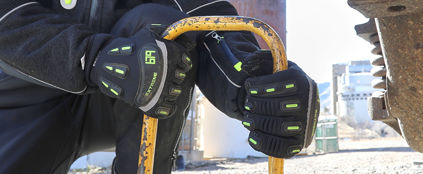 Person moves heavy equipment while wearing extreme cold weather work gloves.