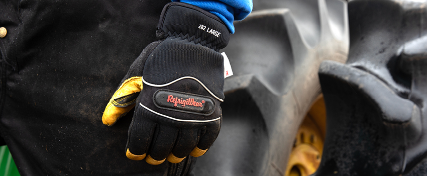 Person wearing a winter work glove works with heavy equipment.