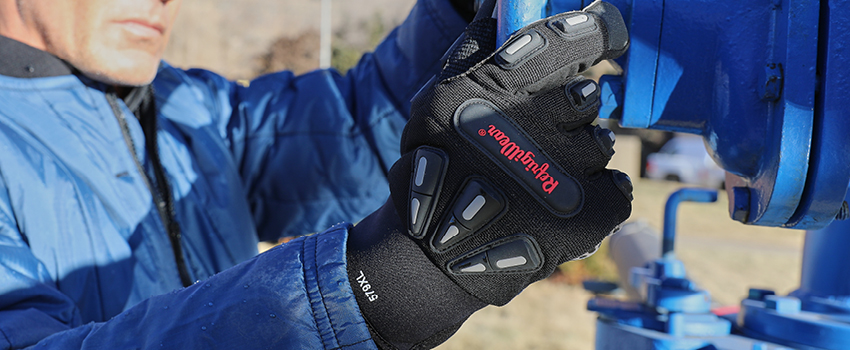 Man working on outdoor utilities wears insulated impact protection gloves.