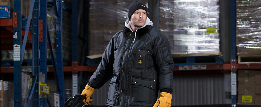 Man operating a pallet jack wears insulated work coat.