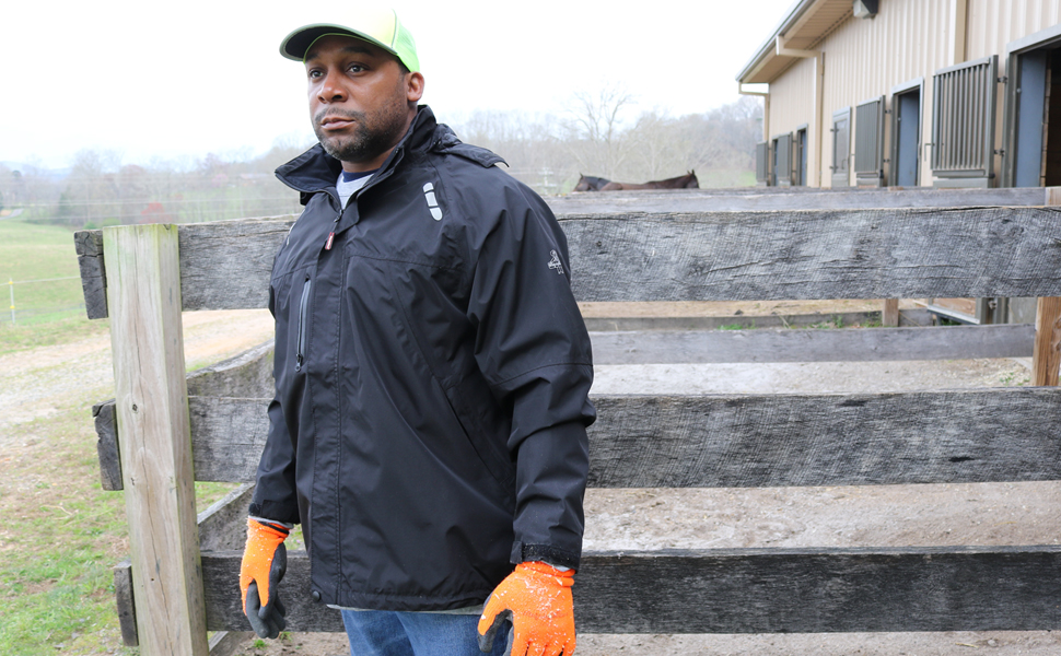 Man in lightweight, water-repellent jacket works on a farm.