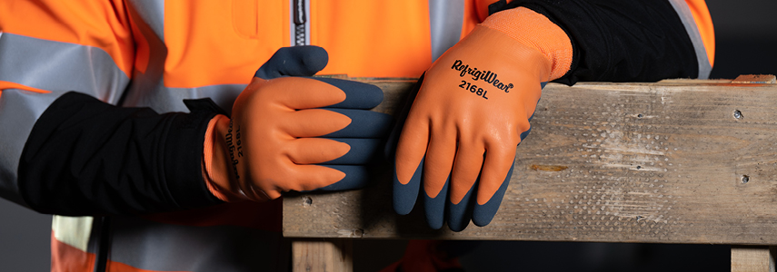 Person wearing high-visibility gear uses coated work gloves to handle pallets and boxes.