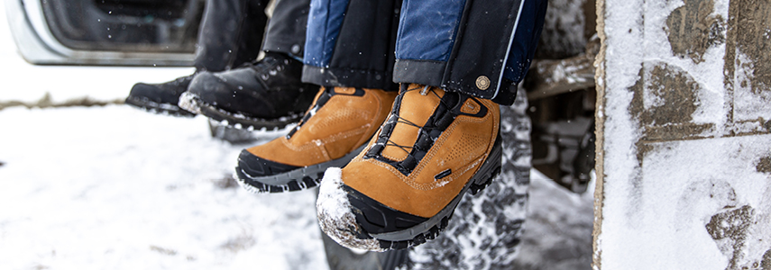 People working in the snow take a break  while wearing insulated leather work boots.