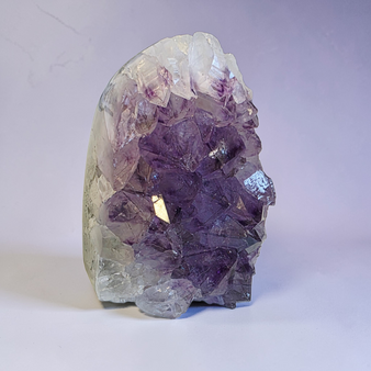 Quality Brazilian Amethyst Large point, upright cluster that features a breathtaking amount of quartz developed behind its purple teeth ? Polished and rounded outer edges with minimal raw rock behind. Majority of weight is high quality Amethyst to Calm your mind and soothe the soul into a more relaxed state - lets be real - your not coping or sleeping - so pick yourself up, buy Amethyst, focus on being relaxed for a short while and proceed at life once more ?❤️