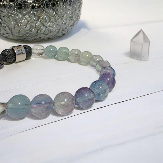 Fluorite is called the aura cleansing and stabilisation stone. Known to absorb and neutralises negative stress energies to increase concentration and focus as well as optimism, positivity and self-confidence. Fluorite's energy may bring together the mind and body for inner balance. Cleanse and set your intentions before you wear, see Care Instructions at Top Main Menu. Fluorites properties align with the Throat and Third Eye Chakras. Fluorite's properties compliment the personality traits of Zodiac Pisces and Capricorn. Combine this bracelet with our Eucalyptus + Lemon Oil Roller with Clear Quartz Shaker Gemstones. Roll onto black volcanic rock beads for aromatherapy benefits of your hand made bracelet.