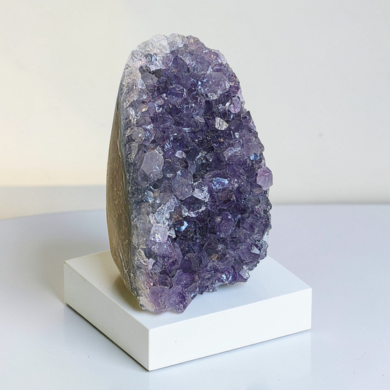 This Quality Brazillian Amethyst Cluster stands alone, weighing 366grams this purple Amethyst beauty has been preserved with as much as 7cm of supporting rock. This Amethyst Cluster has deep indigo purples within centre and bright rainbow violets towards her outer edges. Adopt this 8cm high Amethyst and enjoy the calming and healing properties of Amethyst at home.
Amethyst Properties
Clear your mind & relax with clarity. Amethyst is often worn when one seeks to find intuition in life, clarity about decisions & direction with divine communications. Widely known as good for headaches, the calming vibrational energy flows with you, encouraging peaceful sleep. It's deep indigo purple colour is one that you can easily get lost in, especially good for any fear of the dark. Amethyst's tranquil energy can be most beneficial to those with Obsessive Compulsive Disorder. Amethyst may bring a little inner calm to hyperactive children. It is also found helpful in bringing a gentle sense of comfort for thoughts when worn everyday. Amethyst is the Birthstone fro February. Cleanse and set your intentions before you wear. Amethyst aligns with the Third Eye Chakra. Amethyst closely aligns to the personality traits of Aquarius. Compliment your crystals with our Lavender Oil Roller with Amethyst Shaker Stones. Roll onto black volcanic rock beads for aromatherapy benefits. Also search Amethyst Ring.