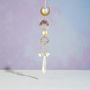A delicate and delightful addition to calm any space. This Suncatcher is made with an Amethyst Tree of Life dangling between a Crescent Moon and Saturn Planet, electroplated glass Gems, Stars and Points to catch and refract light from the sun. Amethyst is calming for the mind and body, for soft peaceful sleep, and enhanced intuition