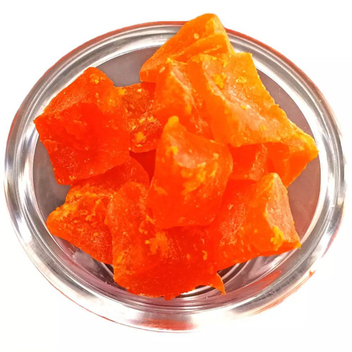Close-up view of Michele’s Pantry sweetened sun-dried papaya chunks in a glass bowl, showing bright orange color and chunky texture.