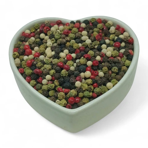A heart-shaped bowl filled with a colorful blend of black, white, green, and pink peppercorns – a gourmet mix that adds both flavor and beauty to any dish.