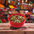 A rustic red bowl filled with the colorful 5 peppercorn mix, set against a lively spice market backdrop for a gourmet appeal.