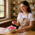 Person preparing a bowl of pink sugar candies in a home kitchen setting.
