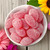 Top view of pink sugar-coated candies in a bowl with bright decorative background.