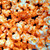 Popcorn coated with bright orange cheddar cheese powder seasoning.
