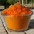 Large bowl filled with vibrant cheddar cheese powder in bulk quantity.
