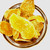 Close-up of Michele’s Pantry sun-dried crystallized ginger pieces in a glass bowl, showing sugar-coated texture and golden color.