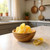 Sun-dried crystallized ginger displayed in a bowl on a kitchen counter, illustrating size, shape, and natural appearance.