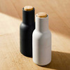 Minimalist black and white AUDO Bottle Grinders on timber surface, soft light.