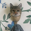 Front view of a hand-carved wooden Grey Cat wall hook with lifelike yellow eyes and hand-painted fur details, mounted on a white wall with floral design.