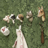A hand-carved Beagle wall hook mounted on a green wall, holding a linen towel, together with four other wall hooks.