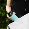 Woman taking a THAT!water bottle from her handbag 