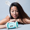 Asian girl looking at CLOCKY, the Aqua Blue Alarm Clock On Wheels