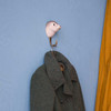 A hand-carved Seal wall hook mounted on a wall, holding a winter coat, adding a marine-inspired touch to a home entryway.