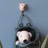 A hand-carved Polar Bear wall hook mounted on a blue wall, holding a backpack with a soft toy.