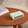 Pantone pastel green alarm clock with flip on/off design on table