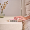 Pantone Rose Quartz alarm clock with flip on/off design on table