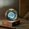 The Gingko Amber Crystal Light in a home setting, providing a cool ambient glow on a wooden surface.
