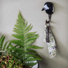 Wildlife Garden Australian Magpie wall hook mounted on a sage green wall, holding a set of keys and a floral-patterned cloth, styled alongside green ferns and a decorative magpie figurine in an Australian-themed interior.