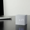 Gingko Cube Click Clock in brushed aluminium sitting on a dark desk next to a laptop displaying 1:17 in glowing white LED.