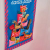 Detailed close-up of the colorful numbered fabric pockets holding dog treats and pet accessories on the Annabel Trends Santa Paws calendar.