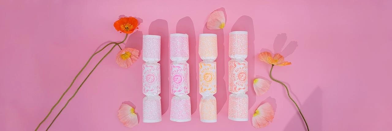 4 bonbon soaps on pink surface with poppies