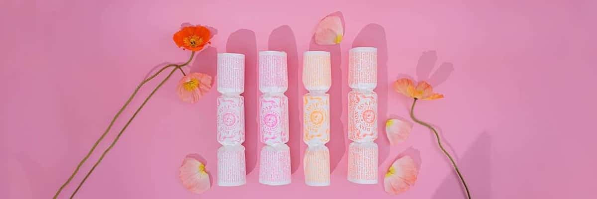 Four bonbon soaps on pink surface with poppies.