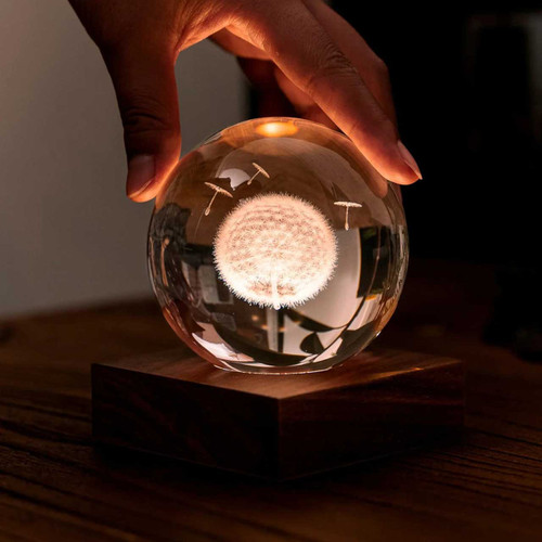 The Gingko Amber Crystal Light in a home setting, with hand touching the sphere.