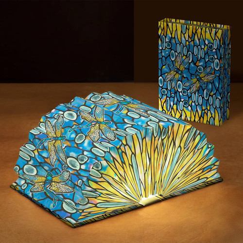 Modgy Louis C. Tiffany Dragonfly Light Book open glowing accordion lamp showcasing stained glass dragonfly pattern beside closed cover.