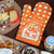 Funny oven mitt "F*ck, I Love Cheese" by BlueQ, sitting beside a cheese platter. 