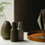 Audo Norm salt & pepper bottle grinder set in hunting green/beige and walnut lid  on a sideboard