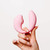 A woman's hand holding the pink Tiff dual-action vibrator, highlighting its ergonomic C-shape for G-Spot and clitoral stimulation. A woman's hand holding the pink Tiff dual-action vibrator, highlighting its ergonomic C-shape for G-Spot and clitoral stimulation.