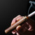 Walnut Element Lighter igniting a cigarette with electric coil.