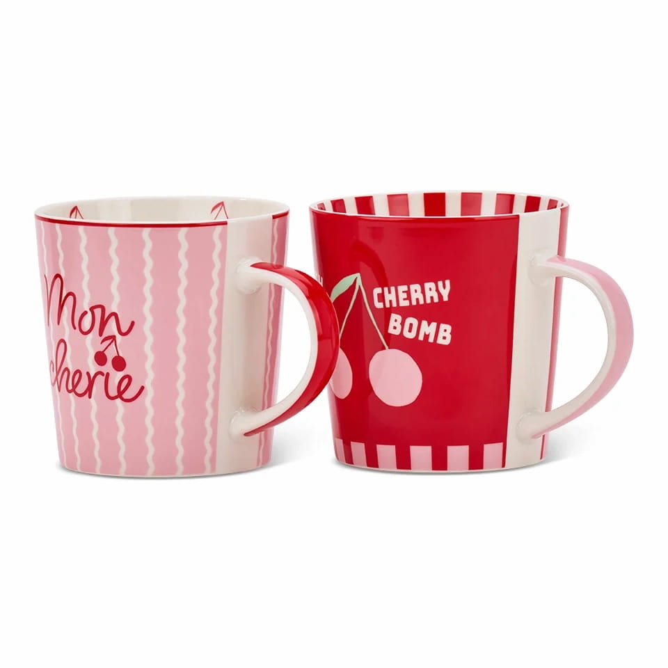 Annabel Trends Cherrylicious 2-piece ceramic mug set showing the pink "Mon Chérie" striped mug alongside the red "Cherry Bomb" mug.