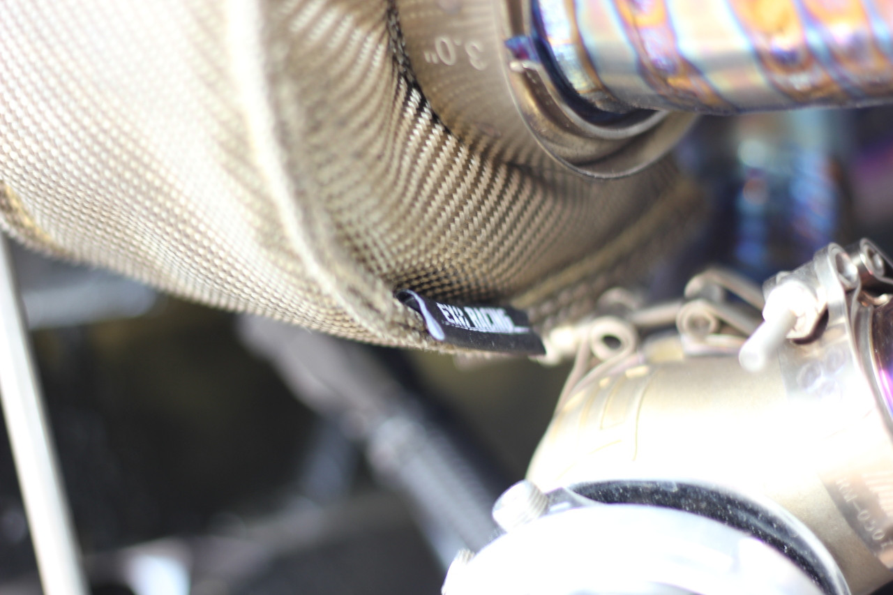 Exoracing turbo blanket fitted around a turbocharger turbine housing to contain engine bay heat