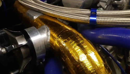 Reflective heat sheet protecting panel near turbo heat