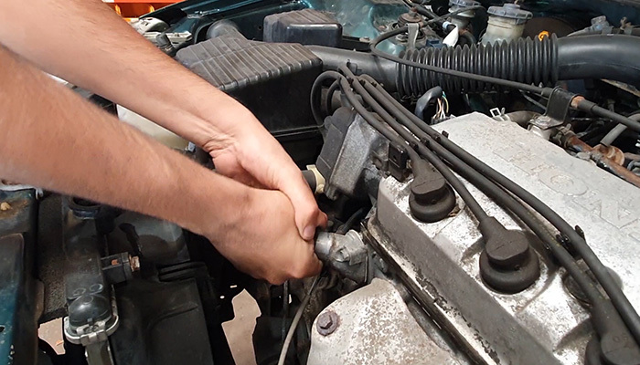 Twisting an old coolant hose to break the seal on the water neck