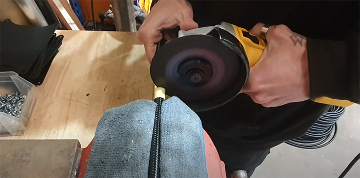 Cutting braided PTFE hose through the taped cut line with a disc cutter